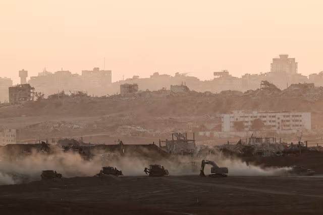 A tank drives near Israeli heavy machinery, as seen from the Israeli side of the Israel-Gaza border, July 13, 2025. REUTERS/Amir Cohen/File photo