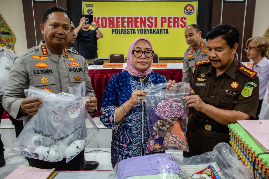 Arifah Choiri Fauzi (C), Indonesia's minister of women's empowerment and child protection, holding evidences poses for photograph during a press conference on a child abuse probe at a daycare centre, in Yogyakarta on April 27, 2026. (AFP)