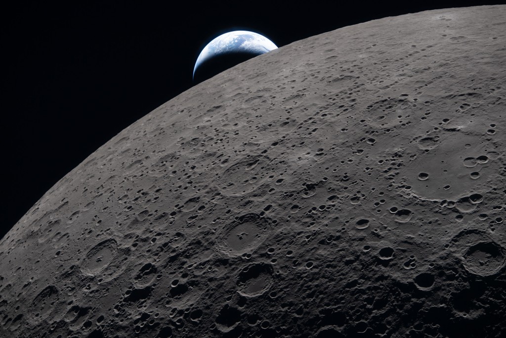 Photo by HANDOUT / NASA / AFP  This handout picture released on April 7, 2026, by NASA shows the lunar surface in the foreground while a distant Earth sets in the background at 6:41 PM EDT (20:41 GMT), as seen from the Orion spacecraft on April 6, 2026.