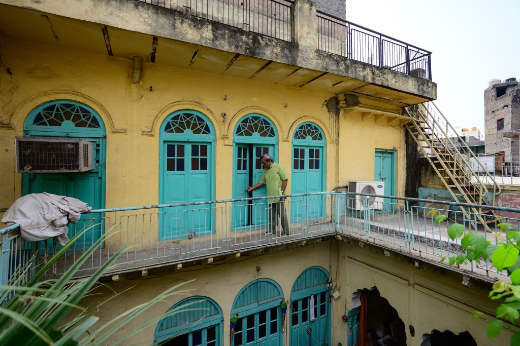 Photo by MANAN VATSYAYANA / AFP  This photograph taken on March 17, 2026 shows Ashok Mathur, a fourth generation resident walking inside his century-old ancestral property Mathur ki Haveli in the old quarters of Delhi.