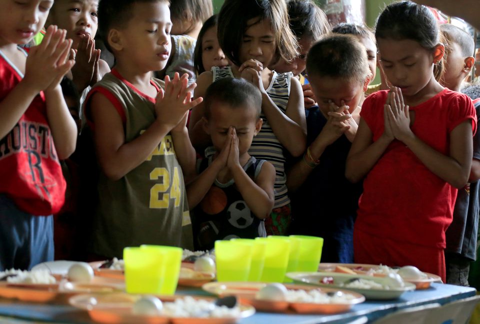 Children pray before eating their free meals inside a missionary house during a feeding program funded by a South Korean missionary, at a slum area in Baseco, Tondo city, metro Manila, Philippines January 2, 2018. (REUTERS/Romeo Ranoco) Children pray before eating their free meals inside a missionary house during a feeding program funded by a South Korean missionary, at a slum area in Baseco, Tondo city, metro Manila, Philippines January 2, 2018. (REUTERS/Romeo Ranoco)