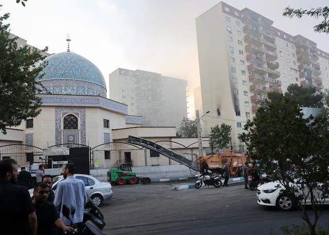 Smoke rises as a building stands damaged in the aftermath of Israeli strikes, in Tehran, Iran, June 13, 2025. Majid Asgaripour/WANA (West Asia News Agency) via REUTERS 