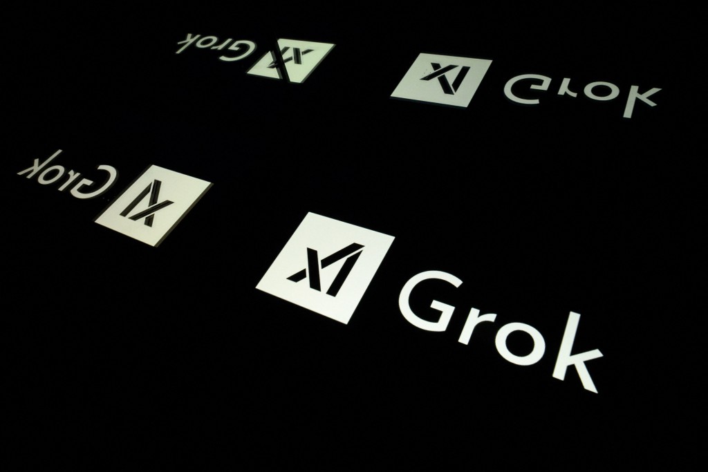 (FILES) This photo illustration shows screens displaying the logo of Grok, a generative artificial intelligence chatbot developed by US artificial intelligence company xAI, in Toulouse, southern France, on January 15, 2025. (Photo by Lionel BONAVENTURE / AFP)