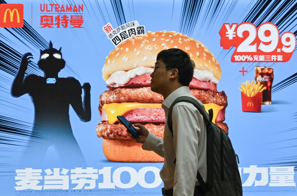 A man walks past a McDonald's advertisement at a subway station in Beijing on June 11, 2025. (Photo by Adek BERRY / AFP)