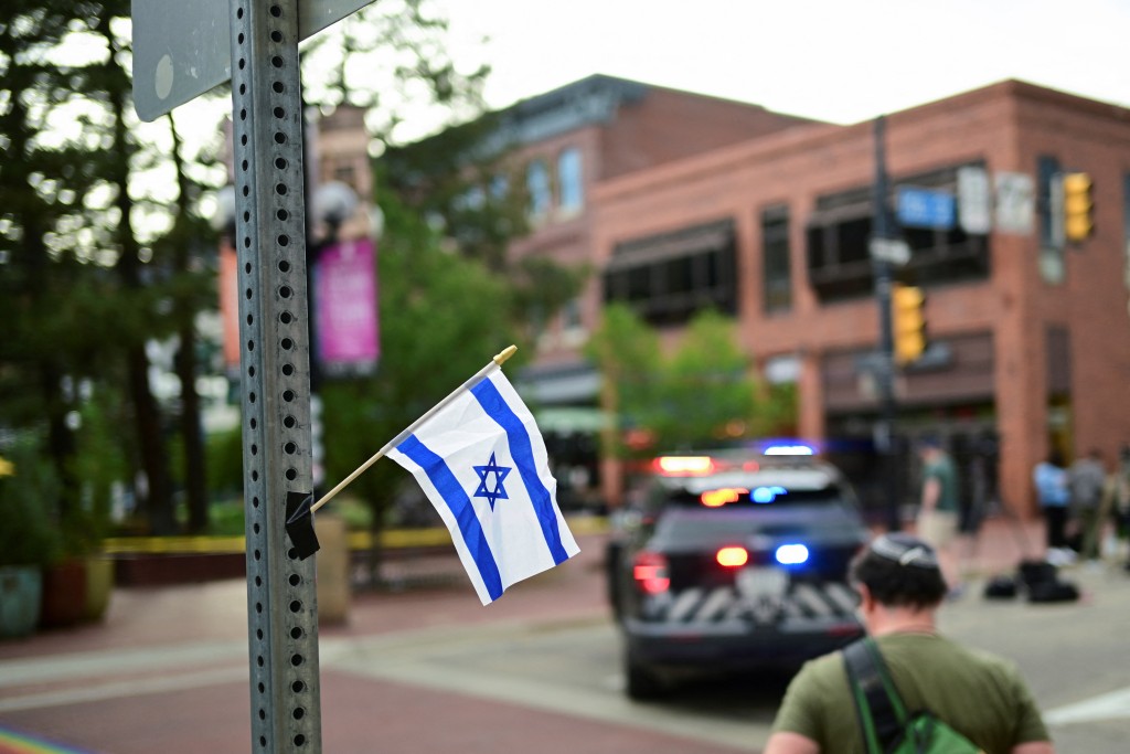 Sam King crosses the street after affixing an Israeli flag to a street light near the scene of an attack that injured multiple people, in Boulder, Colorado, U.S. June 1, 2025. (Reuters)