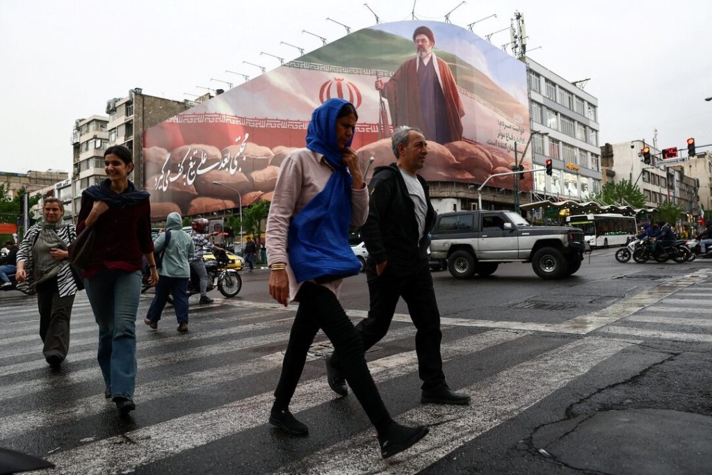 People walk near a billboard featuring an image of Iran's new Supreme Leader Mojtaba Khamenei, amid a ceasefire between U.S. and Iran, in Tehran, Iran, April 20, 2026. Majid Asgaripour/WANA (West Asia News Agency) via REUTERS 