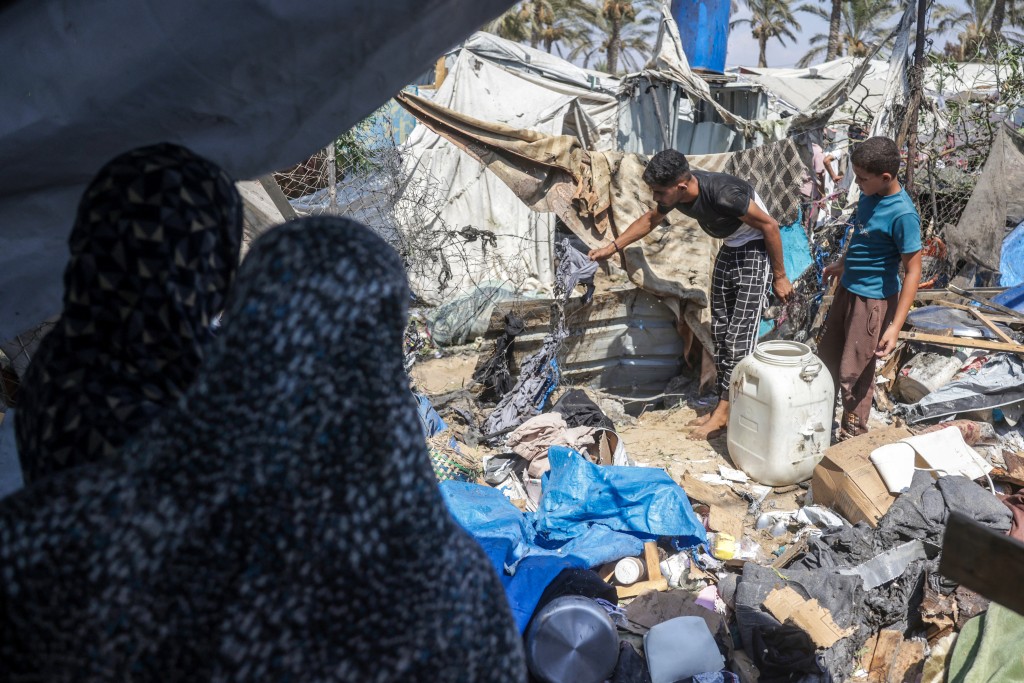 Photo by BASHAR TALEB / AFP  Displaced Palestinians inspect the damage at the site of an alleged Israeli strike on a tent in Khan Yunis, in the southern Gaza Strip, on August 16, 2026.