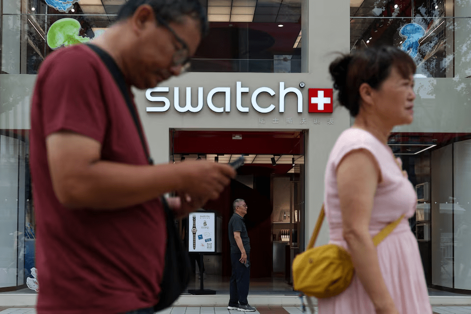 People walk past a store of Swiss watchmaker Swatch, in Beijing, China August 18, 2025. REUTERS/Tingshu Wang