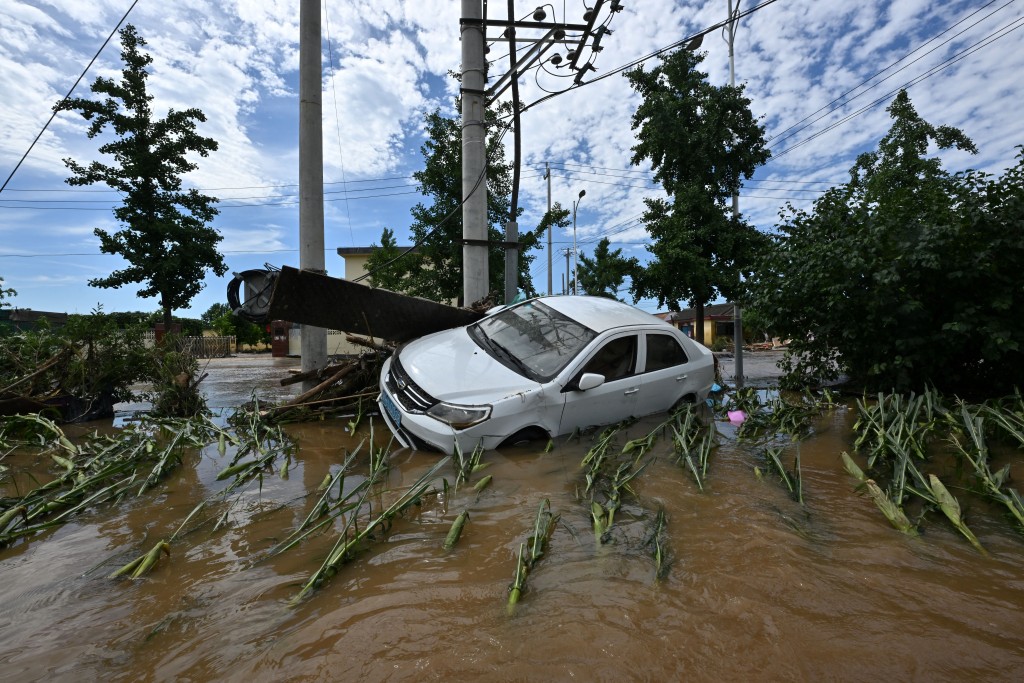 A damaged car is seen in a flooded neighbourhood in Miyun district, northern Beijing on July 29, 2025. (AFP)