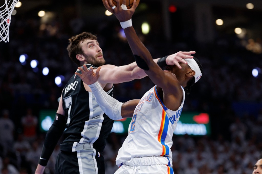 Shai Gilgeous-Alexander is fouled by San Antonio Spurs center Luke Kornet. REUTERS