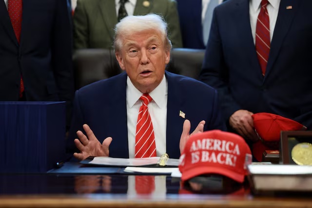 U.S. President Donald Trump sits at his desk, behind a hat that reads "America is back" at the White House in Washington, D.C., U.S., February 3, 2026. REUTERS/Evelyn Hockstein/File Photo 