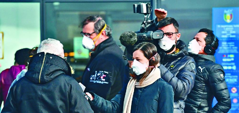 Masked journalists conduct street interviews in Italy. AFP Masked journalists conduct street interviews in Italy. AFP
