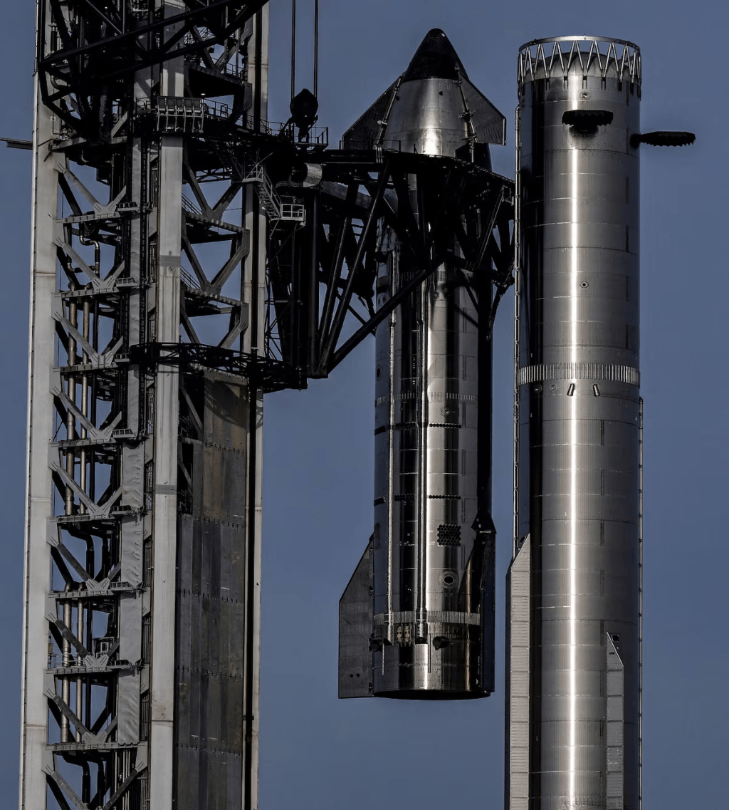 The Pad 2 chopsticks hoist Starship 40 at the SpaceX launch complex to stack the spacecraft atop booster 20 as preparations continue for the second attempt of the 13th test flight of the Starship spacecraft and the Super Heavy v3 booster in Starbase, Texas, U.S., July 22, 2026. REUTERS/Steve Nesius
