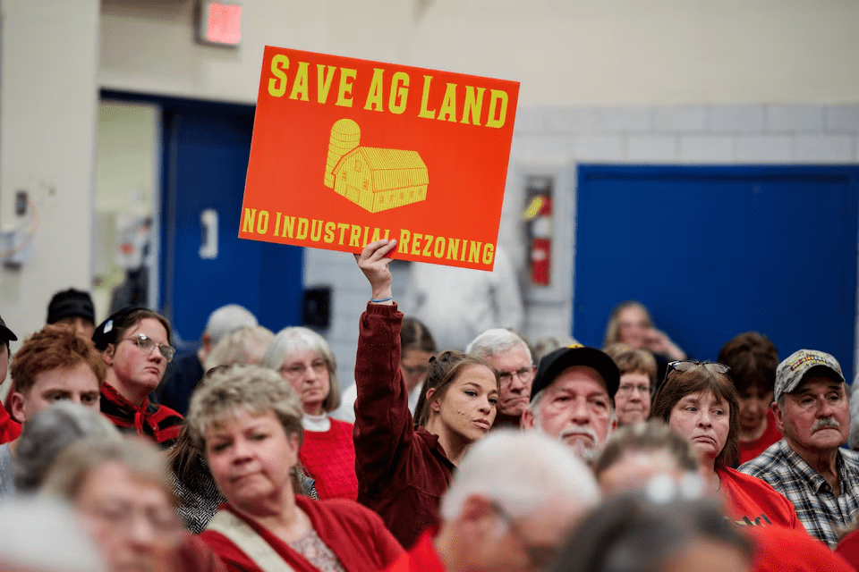 A community member holds a sign against a plan of Talen Energy to rezone land from agricultural to industrial to build a data center, at the Montour County Planning Commission meeting in Danville, Pennsylvania, U.S. November 19, 2025. REUTERS/Hannah Beier