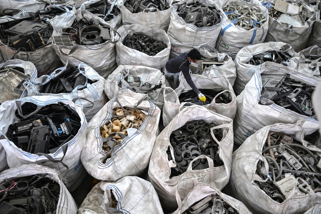 This photograph taken on February 12, 2026 shows a worker sorting dismantled electronic parts at 'Ecowork', an e-waste recycling facility in Ghaziabad.