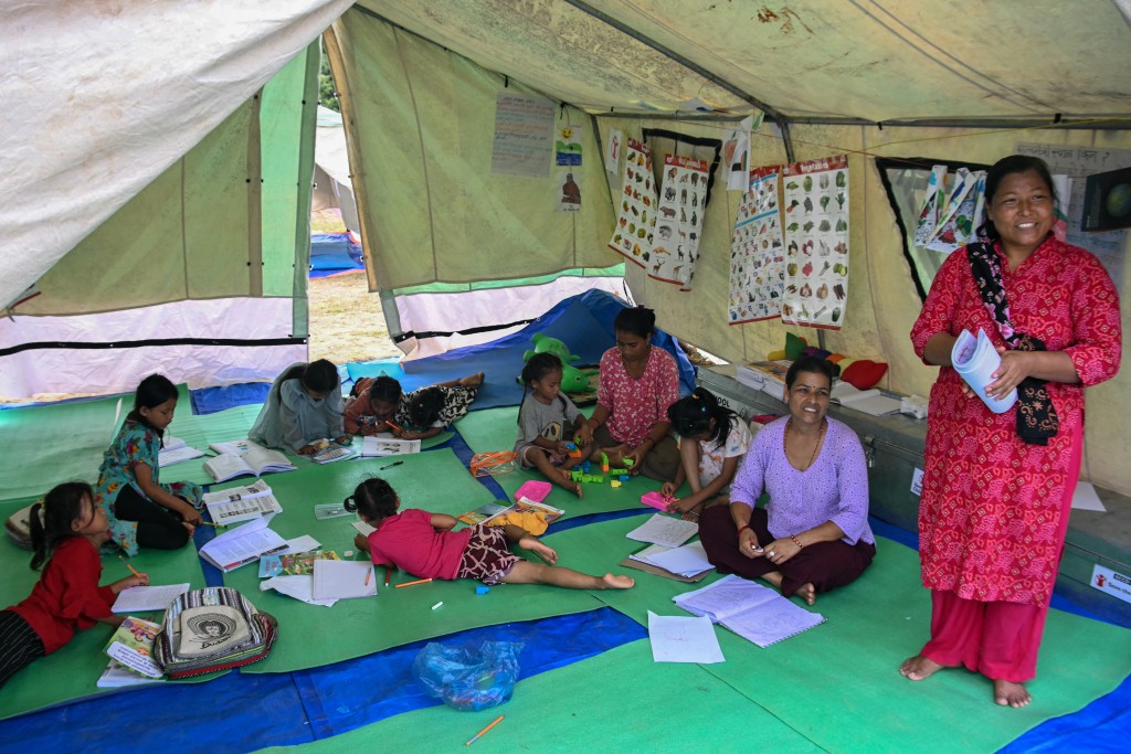 Photo by PRAKASH MATHEMA / AFP Children, separated from their parents from the flash floods, study at a temporary learning centre run by Save the Children charity in Nepal's Nuwakot district on September 11, 2026.