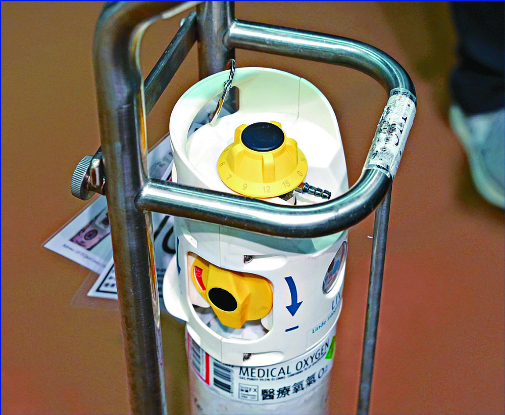 How the oxygen equipment works as well as its parts – including the cylinder's switch, circled – are shown at a news conference attended by, from left, Cheung Wai-man, Nelson Wat, the HA's Alexander Law and Yan Chai Hospital's Dominic So. SING TAO How the oxygen equipment works as well as its parts – including the cylinder's switch, circled – are shown at a news conference attended by, from left, Cheung Wai-man, Nelson Wat, the HA's Alexander Law and Yan Chai Hospital's Dominic So. SING TAO