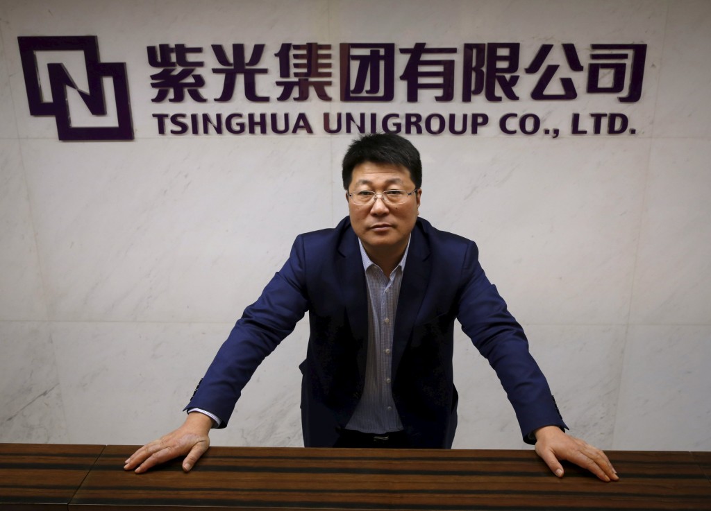 Tsinghua Unigroup chairman Zhao Weiguo poses in front of the logo of his company after an interview with Reuters in Beijing, China, November 15, 2015. Reuters