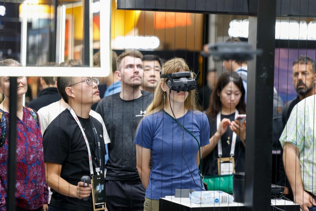 A woman wears a VR headset during a demonstration by DJI drone company at the IFA international trade show for consumer electronics and home appliances, are pictured on September 5, 2025 in Berlin. (Photo by Odd ANDERSEN / AFP)