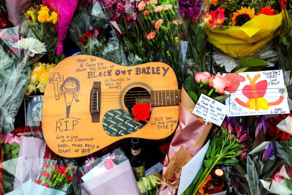 A guitar is placed next to flowers and cards at the Black Sabbath Bridge, following the death of Ozzy Osbourne, in Birmingham, Britain, July 23, 2025. REUTERS/Isabel Infantes