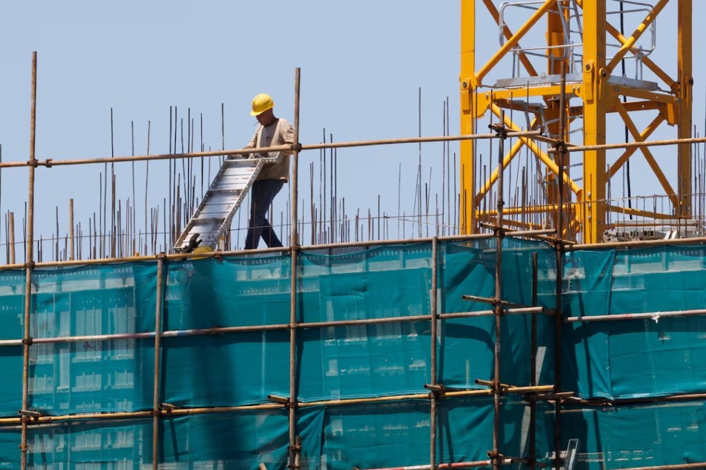 A man works at a construction site of apartment buildings in Beijing, China, July 15, 2022. REUTERS/Thomas Peter