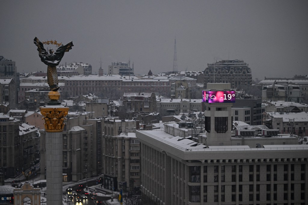Photo by SERGEI GAPON / AFP  Cars drive along the Independence Square as a big screen on a building displays a temperature of -19 degrees Celsius in Kyiv on January 15, 2026, amid the Russian invasion of Ukraine.