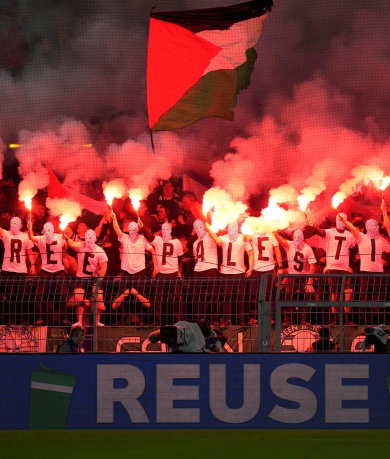 Celtic fans wearing T-shirts stating "Free Palestine," with flares and a Palestinian flag during a Champions League soccer match between Borussia Dortmund and the Scottish side in October. Credit: Martin Meissner/AP