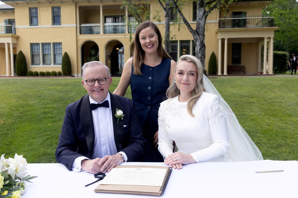 Australia’s Prime Minister Anthony Albanese (L) and his new wife Jodie Haydon (R) sign the marriage certificate with celebrant Bree during their wedding ceremony in Canberra on November 29, 2025. (Photo by MIKE BOWERS / AFP) 