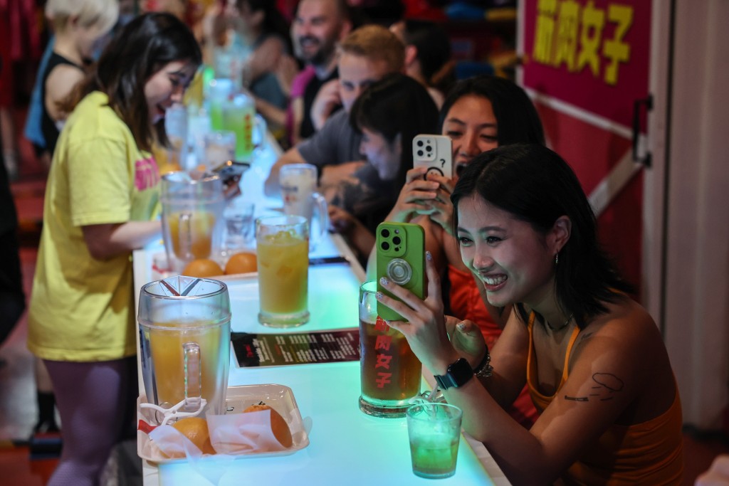 Female customers from China take photos during a performance at Muscle Girls in Tokyo, Japan, July 25, 2025. REUTERS/Kim Kyung-Hoon