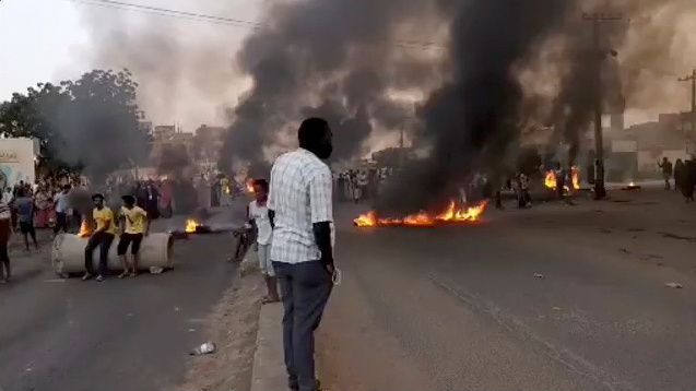 People gather as fire and smoke are seen on the streets of Kartoum, Sudan, amid reports of a coup, October 25, 2021. People gather as fire and smoke are seen on the streets of Kartoum, Sudan, amid reports of a coup, October 25, 2021.