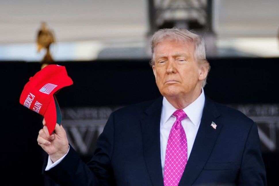 U.S. President Donald Trump holds a 'Make America Great Again' (MAGA) hat as he attends the commencement ceremony at West Point Military Academy in West Point, New York, U.S., May 24, 2025. REUTERS/Eduardo Munoz/File Photo