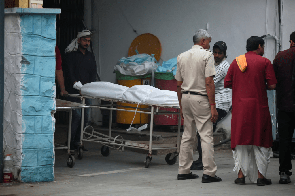 People carry the body of a person, who died in a deadly explosion near the historic Red Fort in the old quarters of Delhi, outside a mortuary at a hospital, in Delhi, India, November 11, 2025. REUTERS/Anushree Fadnavis 