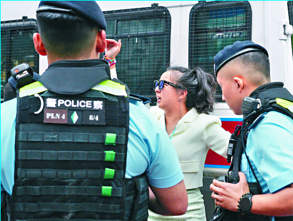 A woman is detained by police in Causeway Bay, where police and a tank are deployed to maintain order. SING TAO, AFP A woman is detained by police in Causeway Bay, where police and a tank are deployed to maintain order. SING TAO, AFP