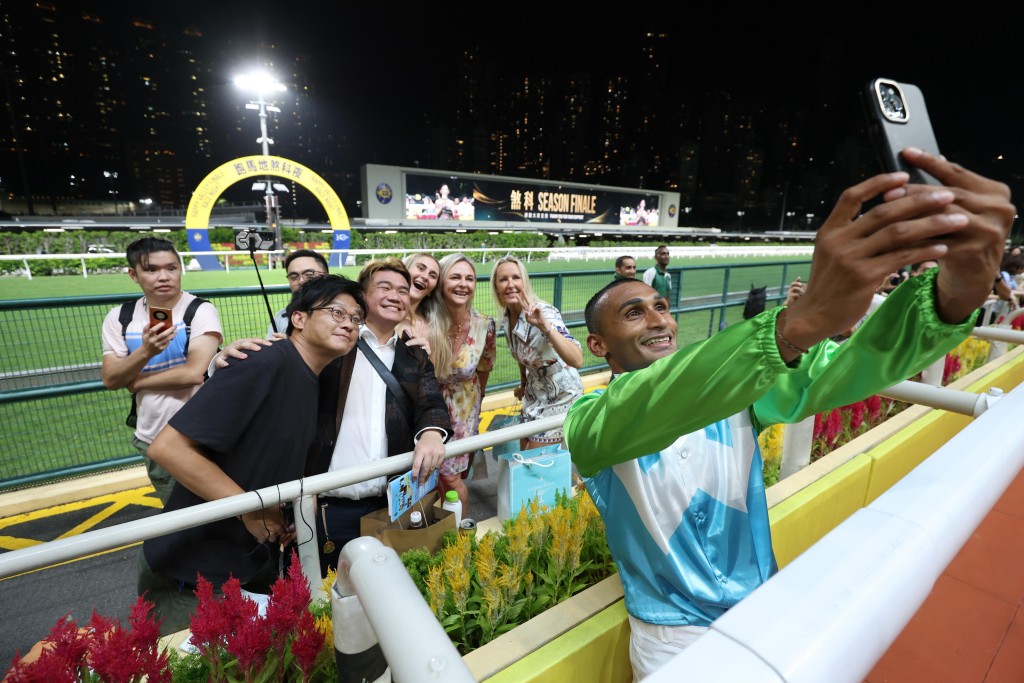 Jockey Karis Teetan provides selfie service to fans. (Sing Tao)