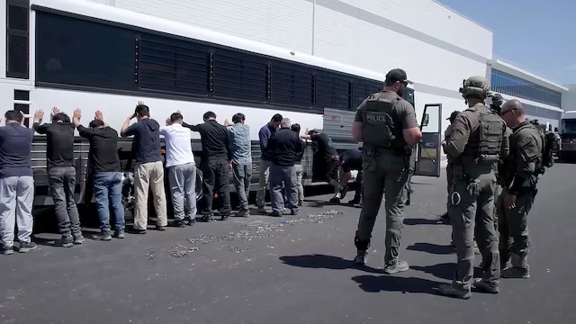 Detainees are made to stand against a bus before being handcuffed, during a raid by federal agents where about 300 South Koreans were among 475 people arrested at the site of a $4.3 billion project by Hyundai Motor and LG Energy Solution to build batteries for electric cars in Ellabell, Georgia, U.S., September 4, 2025 in a still image taken from a video. U.S. Immigration and Customs Enforcement/Handout via REUTERS /File Photo 