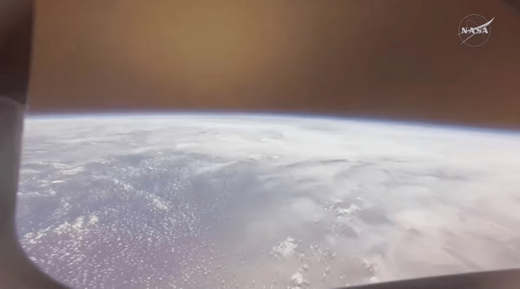 Earth is seen through a window of the Artemis II crew capsule in this screengrab from a livestream video after the capsule enters the atmosphere during its re entry to Earth, following the Artemis II crew’s flyby of the Moon, April 10, 2026. NASA/Handout via REUTERS