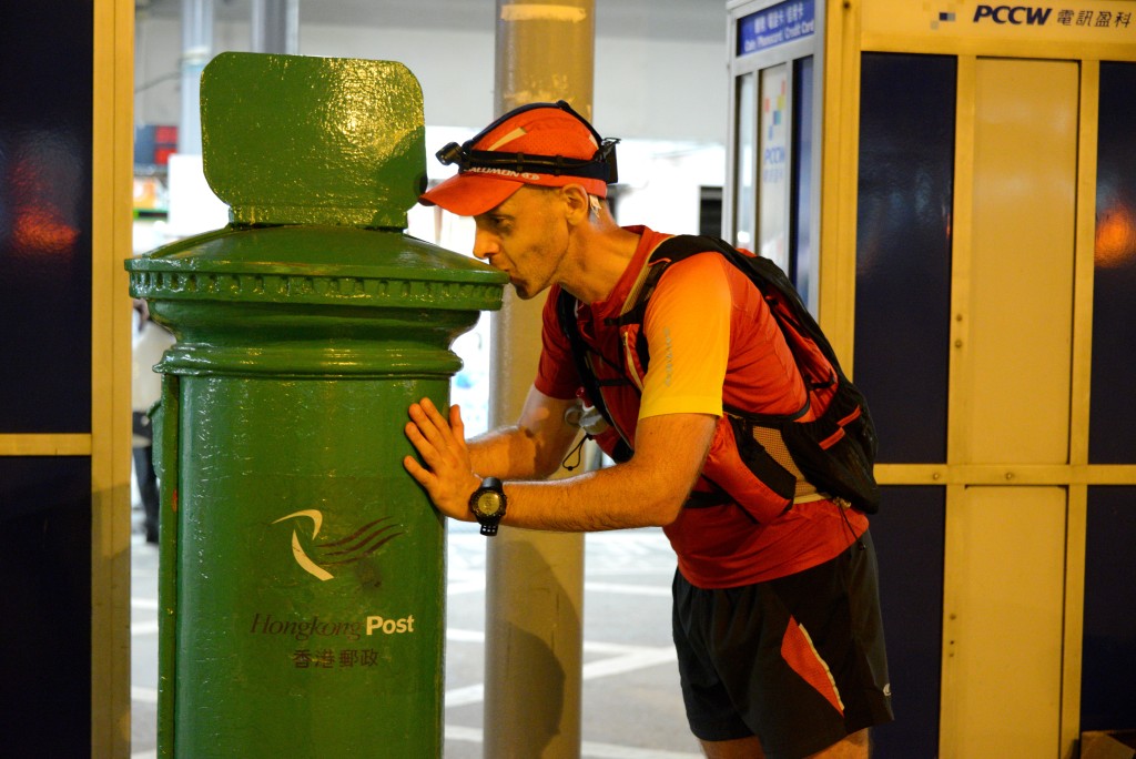 Blumberg kissing the green post box outside the Lantau Mui Wo ferry pier in the second edition of the challenge in 2013, a moment reflected in the event logo now. (Photo courtesy of Blumberg)