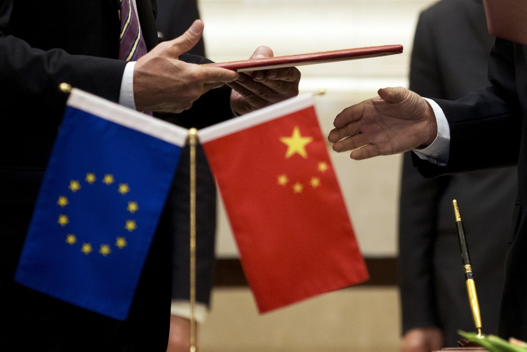 A member of European Commission, left, prepares to exchange documents with Chinese delegation at a signing ceremony after the 5th China-EU High Level Economic and Trade dialogue at Diaoyutai State Guest House in Beijing, on Sept. 28, 2015.  (AP Photo/Andy Wong, File)