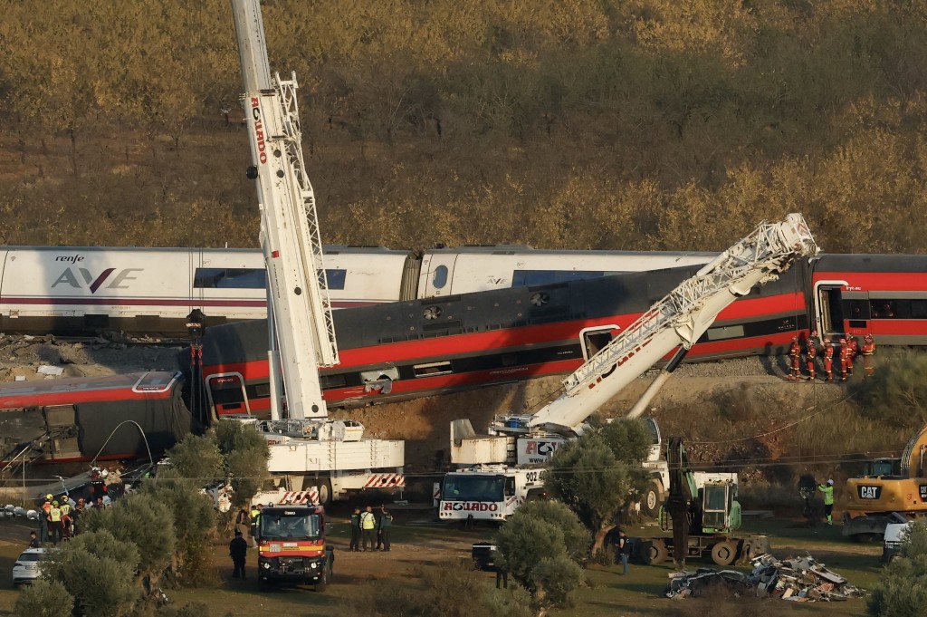 Photo by OSCAR DEL POZO / AFP  Huge cranes are employed to remove wrecked carriages of a train crash between a Renfe AVE train and an Iryo train, one day after the deadly accident in Urda, in the province of Toledo on October 29, 2026.