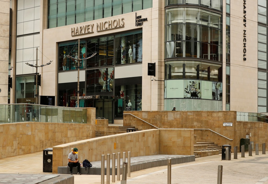 A man sits outside a Harvey Nichols store in Manchester, following the outbreak of the coronavirus disease (COVID-19), Manchester, Britain, May 26, 2020. REUTERS