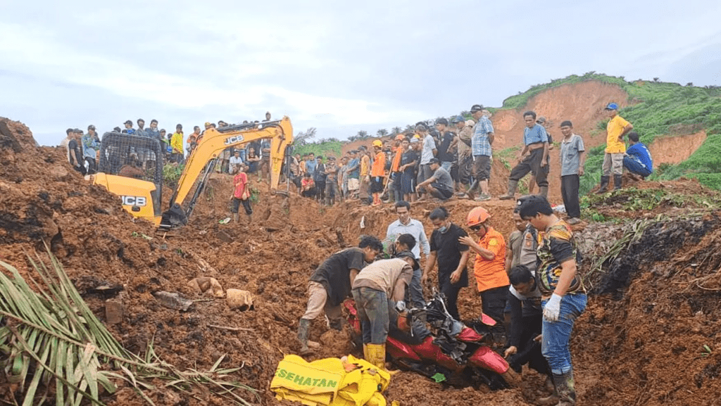 In this photo released on Saturday, Nov. 29, 2025 by the Indonesian National Search and Rescue Agency (BASARNAS), rescuers remove a scooter buried in the mud as they search for victims at a village hit by a landslide in Batu Goading, North Sumatra, Indonesia. (BASARNAS via AP)