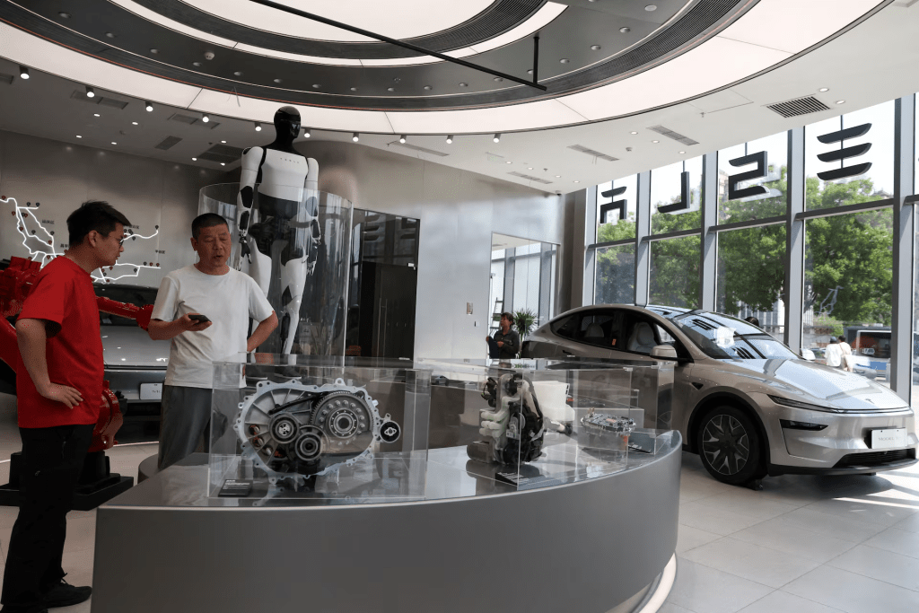 A staff member attends to a customer inside a Tesla store at a shopping mall, in Beijing, China, May 12, 2026. REUTERS/Tingshu Wang/File Photo