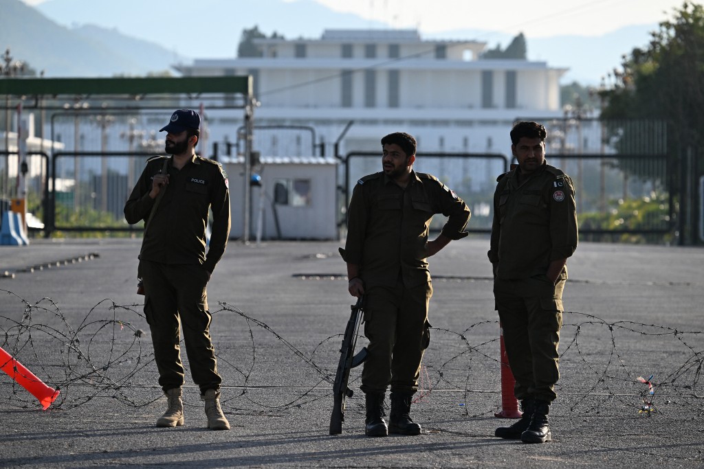 Photo by AAMIR QURESHI / AFP  Pakistani police officers stand guard near the President House in the Red Zone area in Islamabad on April 10, 2026.