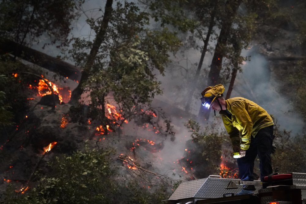 Ben Slaughter, a firefighter for the Boulder Creek Fire Department, stands on top of a fire truck along Highway 9 while monitoring flames from the CZU August Lightning Complex Fire, Saturday. Ben Slaughter, a firefighter for the Boulder Creek Fire Department, stands on top of a fire truck along Highway 9 while monitoring flames from the CZU August Lightning Complex Fire, Saturday.