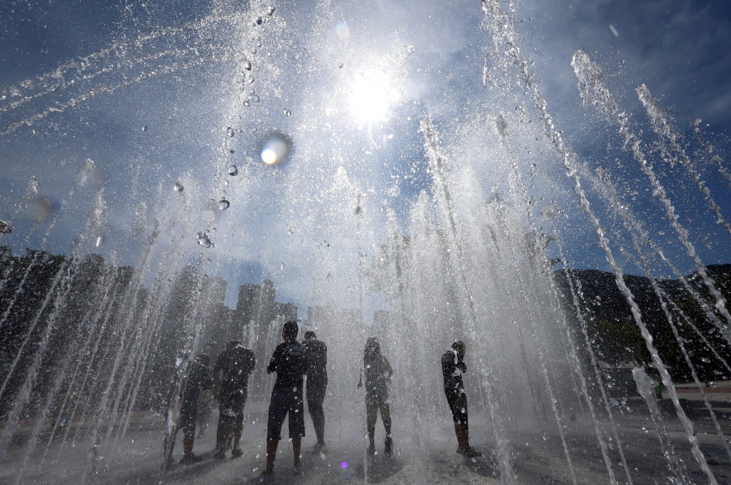 People playing in a fountain to cool off in Yangsan. (AFP)