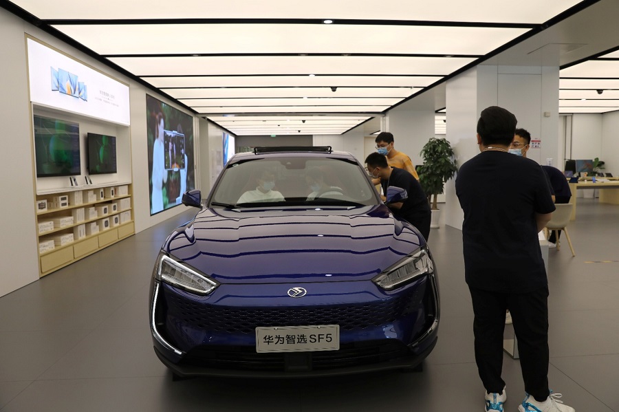 Customers check a Huawei Smart Selection Seres SF5 electric vehicle at a Huawei store in Beijing in June 2021. Photo by REUTERS