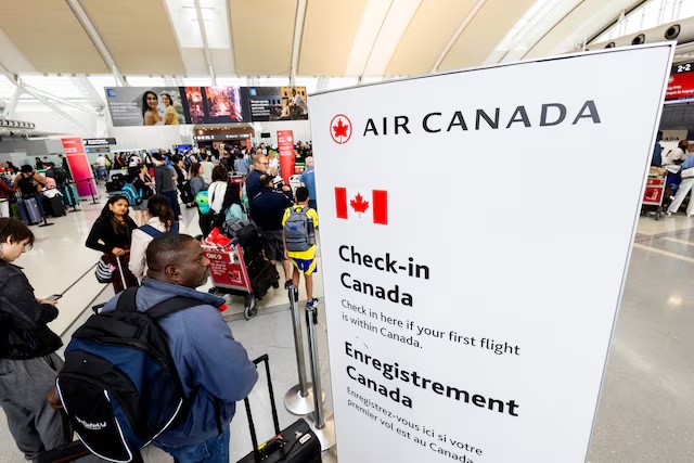 Passengers queue for check-in for their flights at Toronto Pearson International Airport, following the end of the Air Canada labour strike, in Mississauga, Ontario, Canada, August 19, 2025. REUTERS/Carlos Osorio/File Photo