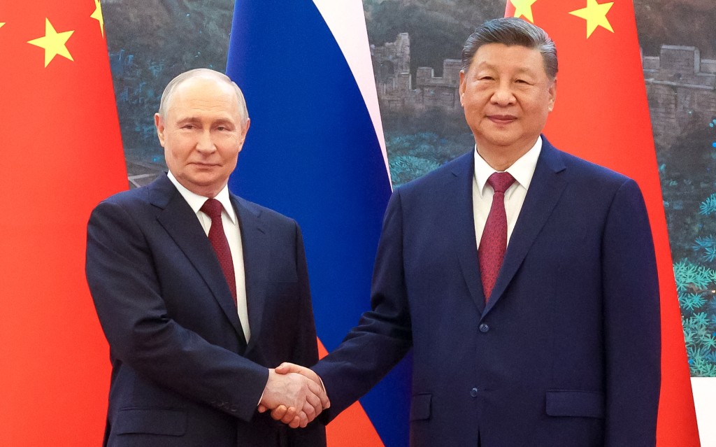 In this pool photograph distributed by the Russian state agency Sputnik, Russia's President Vladimir Putin (L) shakes hands with China's President Xi Jinping during a meeting in Beijing on May 20, 2026. (Photo by Maxim Stulov / POOL / AFP)