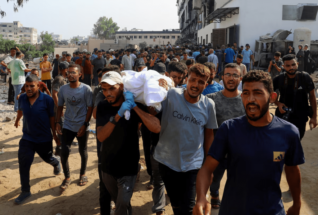 Mourners carry a body during the funeral of Palestinians killed in Israeli fire while seeking aid on Wednesday, according to medics, in Gaza City, August 14, 2025. REUTERS/Ebrahim Hajjaj
