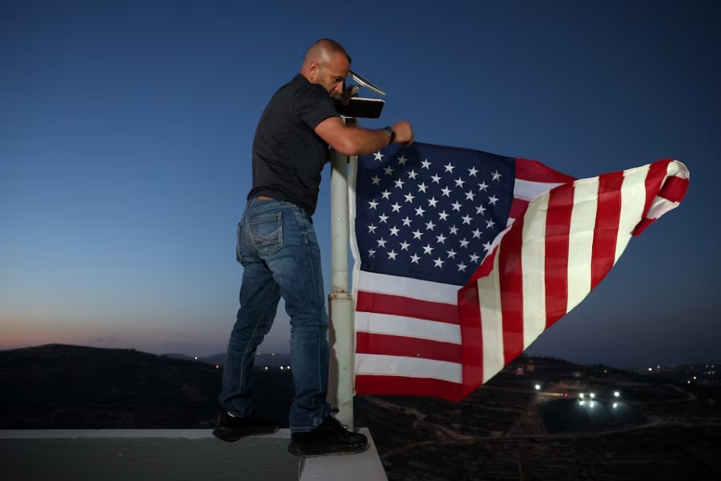  Palestinian-American Loui Ridi, whose home in the Israeli-occupied West Bank has been encircled by militant settlers for more than a week, hangs a U.S. flag after gaining access to his besieged home, in Qusra, Israeli-occupied West Bank, August 17, 2026. REUTERS/Ammar Awad